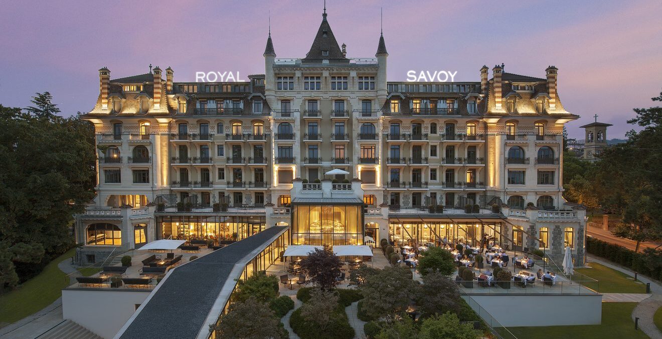 Beleuchtete Südfassade des Royal Savoy Lausanne in der Abenddämmerung